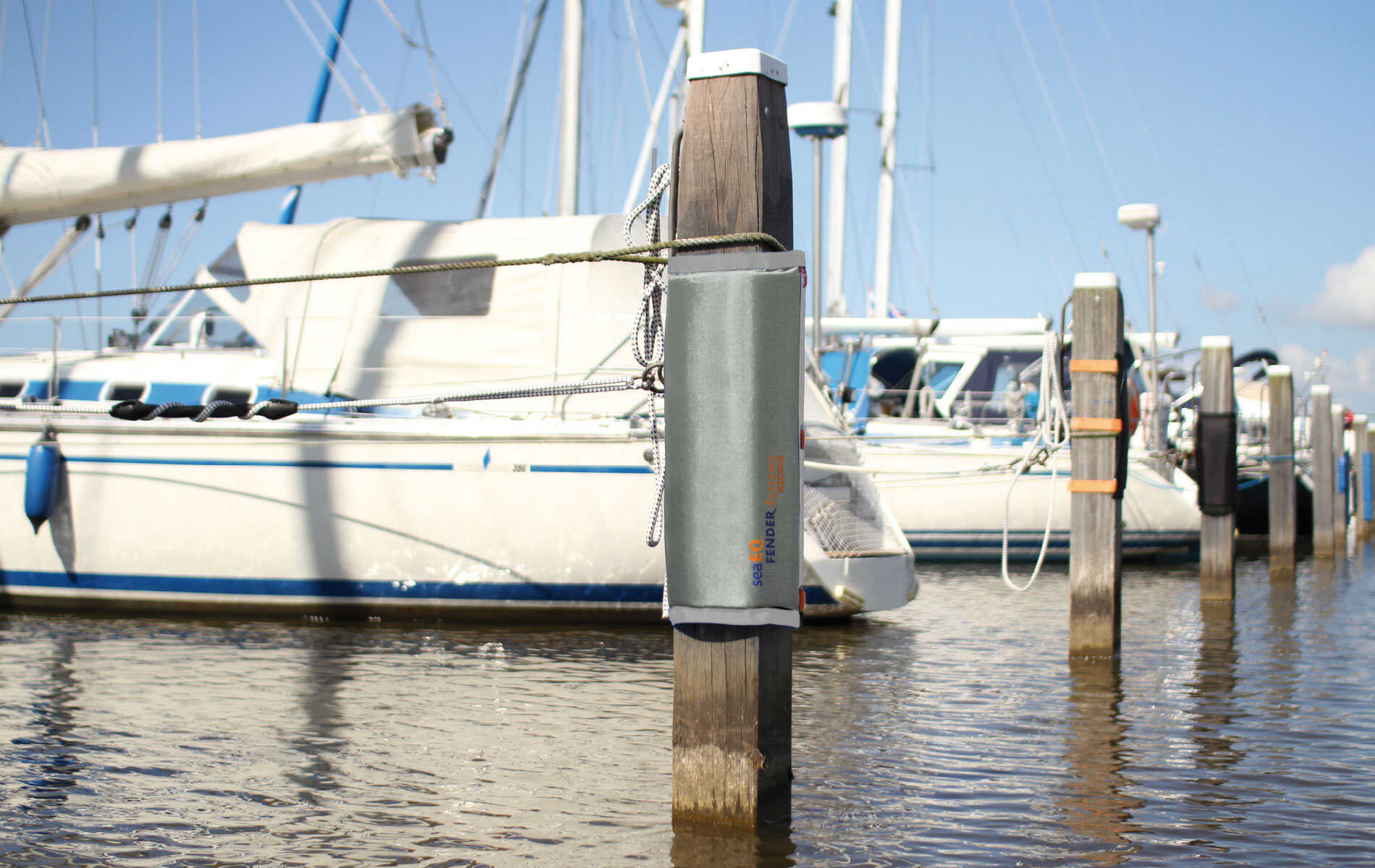 Grauer Dalbenfender PF 40/60 sicher am Pfahl befestigt mit Spanngurten